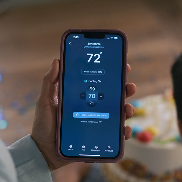 homeowner using an iphone to control their thermostat